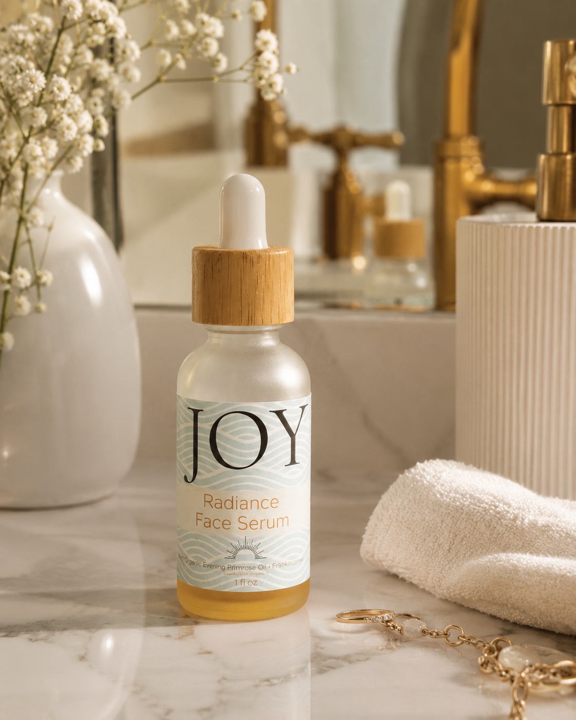 JOY Radiance Face Serum on a marble vanity beside a folded towel